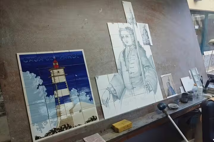Traditional Portuguese azulejos depicting a lighthouse and historical figure on display during Setúbal and Arrábida wine tour.