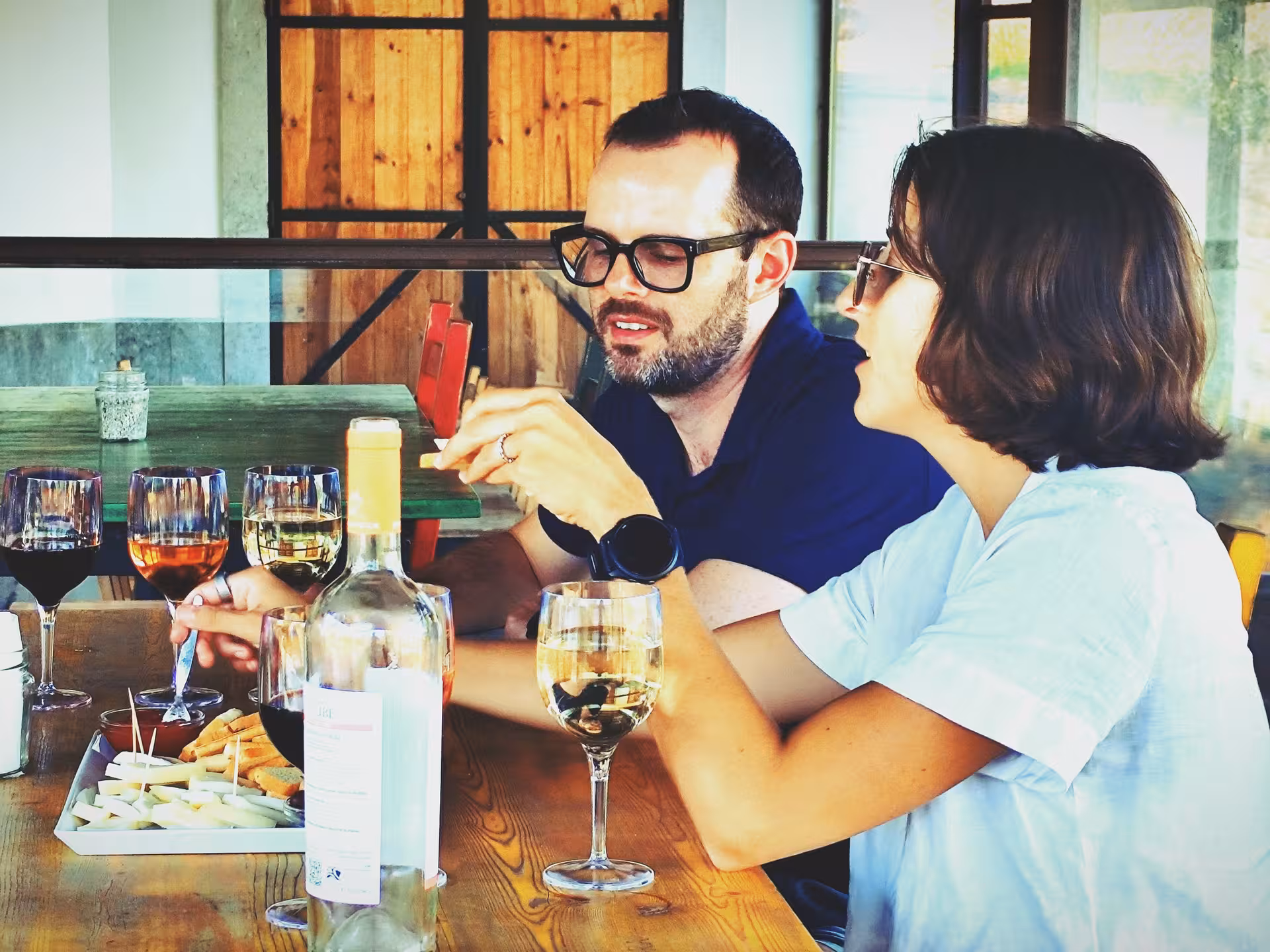 Arrábida wine tour food tasting with couples enjoying Portuguese red and white wines, cheeses and tapas