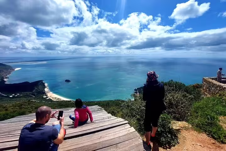 Tourists enjoying breathtaking ocean views from Arrábida Natural Park during Setúbal and Arrábida Food and Wine Tour.