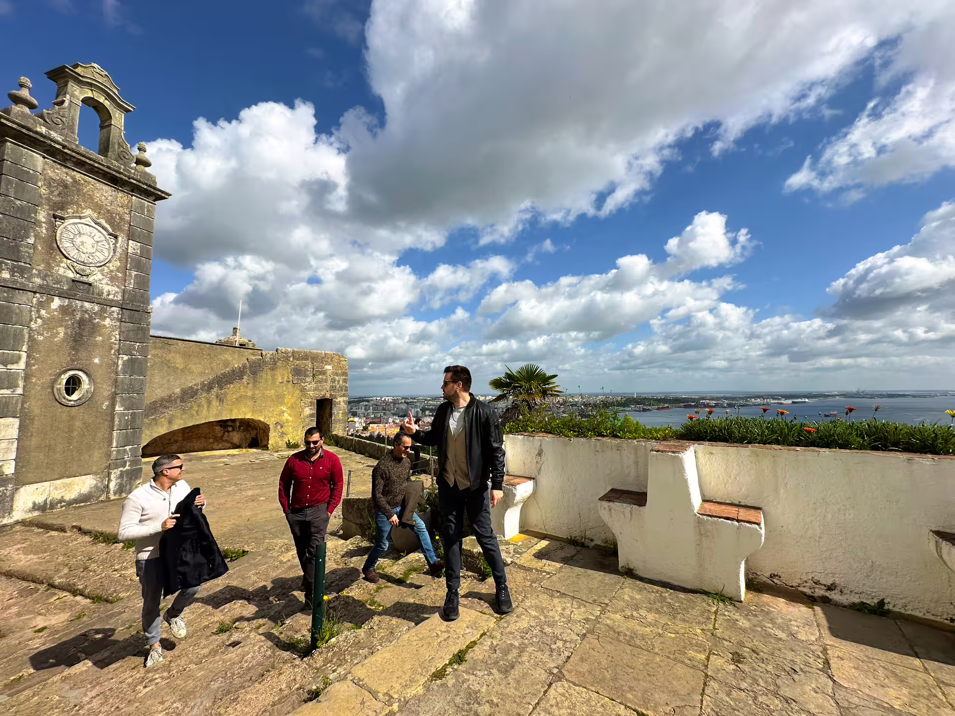 Visitors explore a historic fort with stunning coastal views in Setúbal during the Arrábida private van tour.