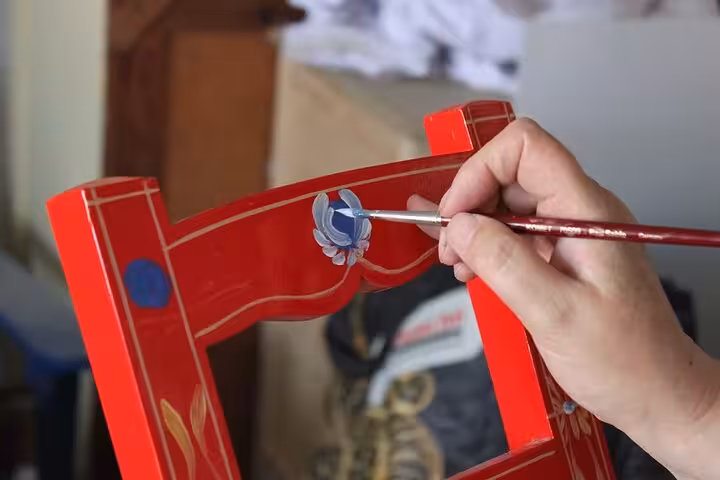 Close-up of intricate hand-painting on a wooden chair in Arraiolos, highlighting local craftsmanship on a guided tour.