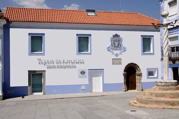 Tapestry museum in Arraiolos with a classic facade and red-tiled roof, highlighting cultural heritage on a walking tour.