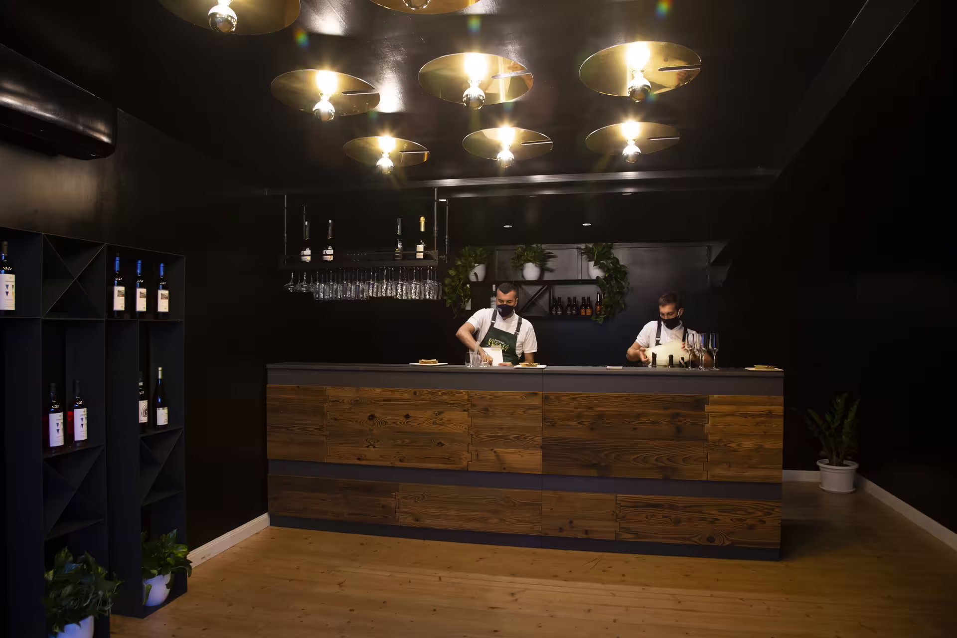 Artisan pasta chefs prepare fresh dishes behind a modern wooden bar during the Visita al pastificio tasting tour