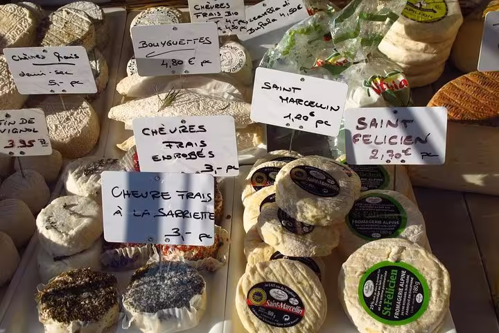 Assortment of artisanal French cheeses on display at a market stall in Nice, perfect for a private food tour experience.