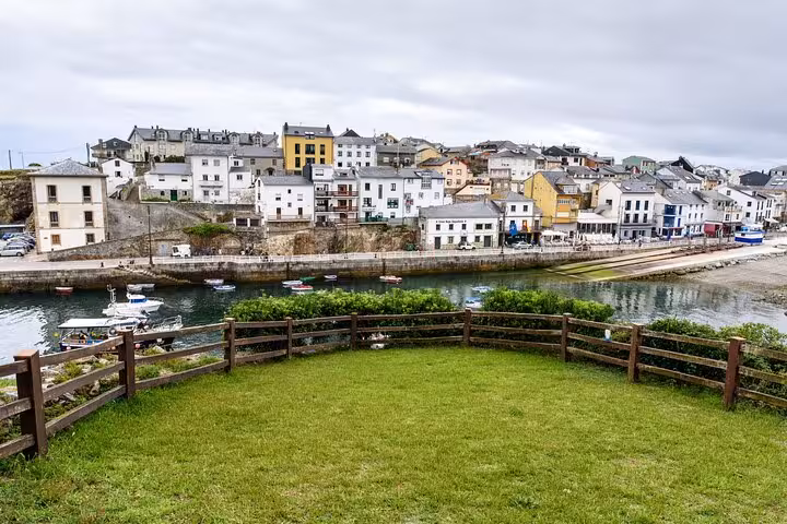 Charming coastal village view in Asturias with colorful houses and boats, ideal for a scenic Spanish getaway.