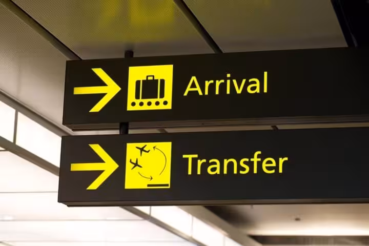 Airport arrival and transfer sign guiding travelers to pre-booked Aswan airport pickup and private transfer service