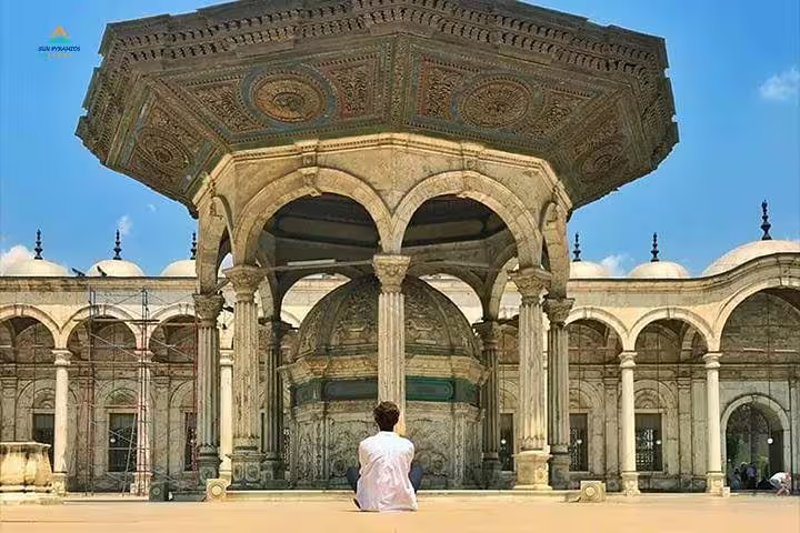 Traveler at ablution fountain in Cairo Citadel mosque courtyard, part of Aswan to Cairo flight day tour
