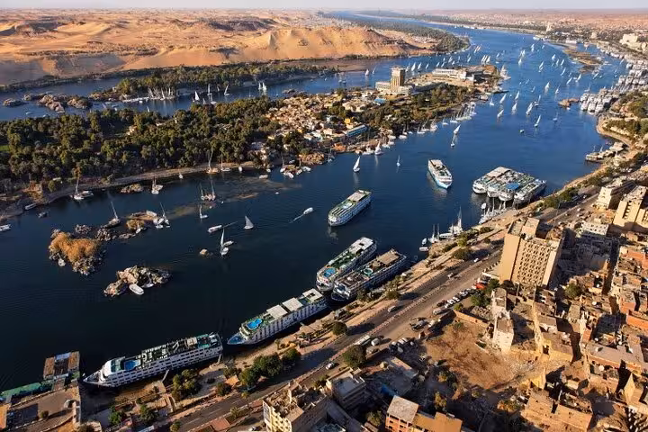 Aerial view of Aswan on the Nile with feluccas and cruise ships, featured in a 7-day private Egypt tour