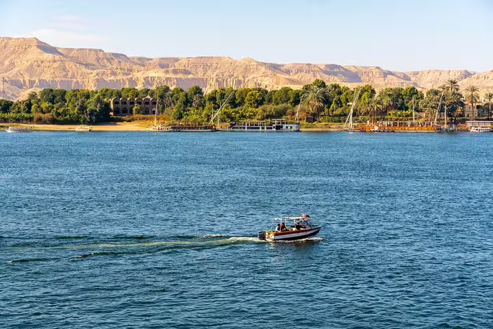 Nile River cruise view in Aswan with boat and desert hills, part of private tour to Philae Temple and High Dam