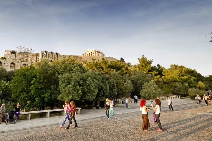 Visitors walking near the Acropolis hill in Athens during a private half-day sightseeing ride with stops