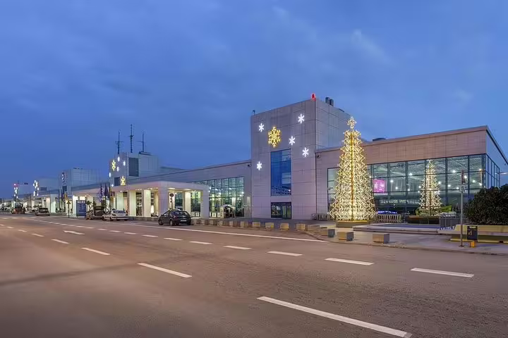 Athens airport terminal at dusk, convenient meet-and-greet start for private transfer from Athens to Delphi