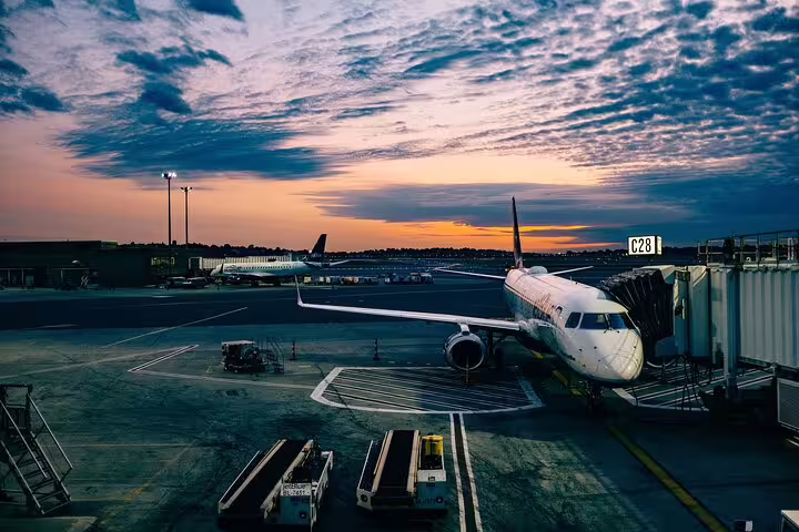 Athens airport terminal at sunset with aircraft at gate, seamless private transfer to city and 1-hour highlights tour