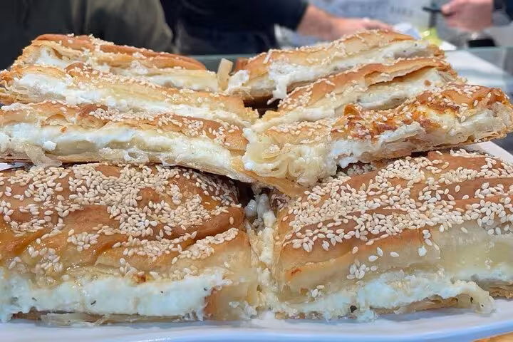 Close-up of Greek bougatsa pastry with creamy filling and sesame topping on an Athens food tour
