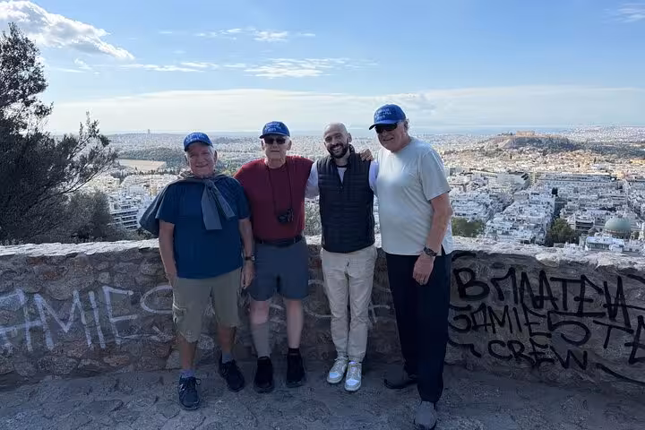 Private Athens city tour guests at Lycabettus Hill viewpoint with panoramic skyline in the background
