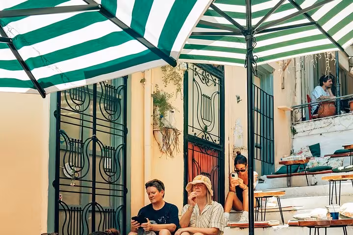 Cruise travelers enjoy Athens food tasting stop at a shaded Plaka cafe on a small group walking tour