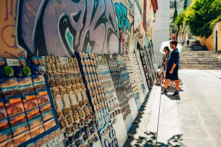 Cruise travelers browse Athens street art and souvenir stalls on a small group walking and tasting tour