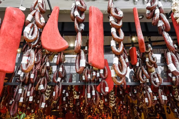Variety of hanging cured sausages in Athens market showcasing authentic Greek flavors on a culinary adventure.