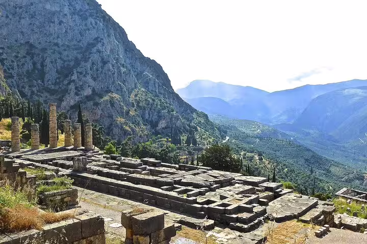 Scenic view of ancient Delphi ruins with mountainous backdrop on private tour from Athens to Delphi and Meteora.