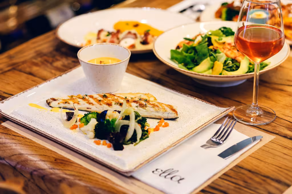 Greek taverna meal with grilled fish, fresh salad and wine, featured on a private Athens food experience