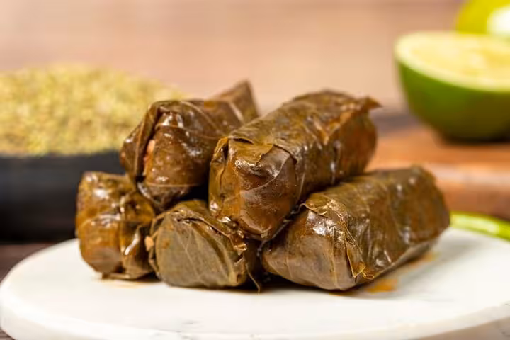 Discover authentic Greek dolmades on our Athens food tour, showcasing traditional stuffed grape leaves with lemon.