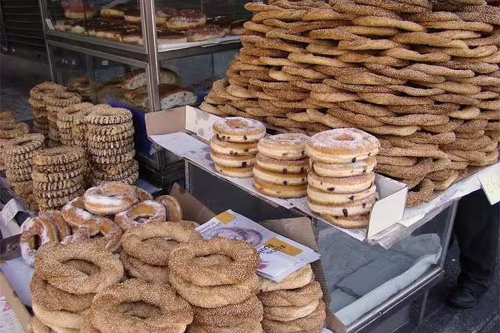 Stacks of sesame koulouri and sweet pastries at an Athens market stop on a small-group afternoon food tour