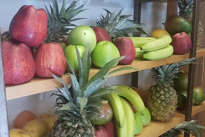 Fresh fruit display of apples, bananas and pineapples at an Athens market on a small-group morning food tour