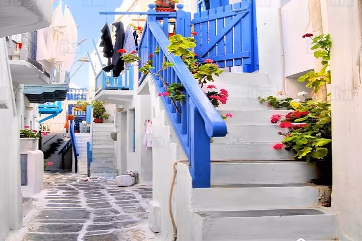 Mykonos Town alley with blue stairway and bougainvillea, seen on a day tour from Athens to Mykonos