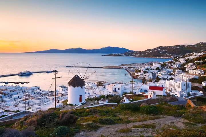 Sunset view over Mykonos Town windmill and harbor, a highlight on the Athens to Mykonos day tour