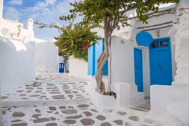 Whitewashed Mykonos street with blue doors and cobblestones in Chora, From Athens day tour to Mykonos