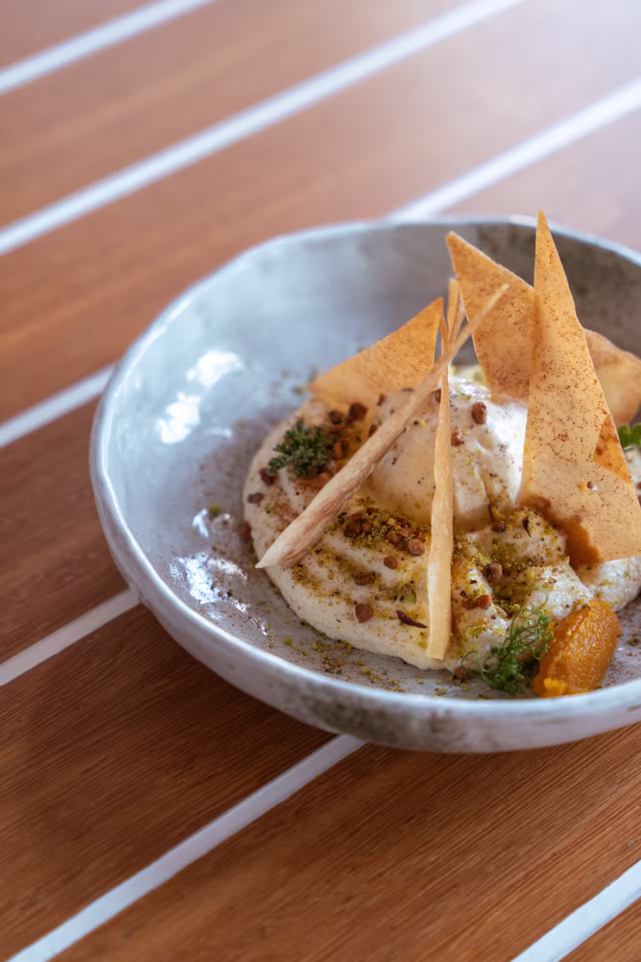 Elegant Greek dish with crisp pita triangles, creamy cheese, and herbs, part of the Athens Mythology Dinner Experience.