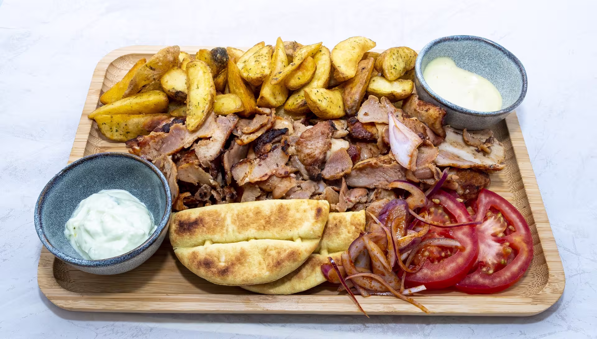 A delicious Greek platter featuring roasted meat, pita bread, tzatziki, and vegetables, highlighting an authentic Athens dining experience.