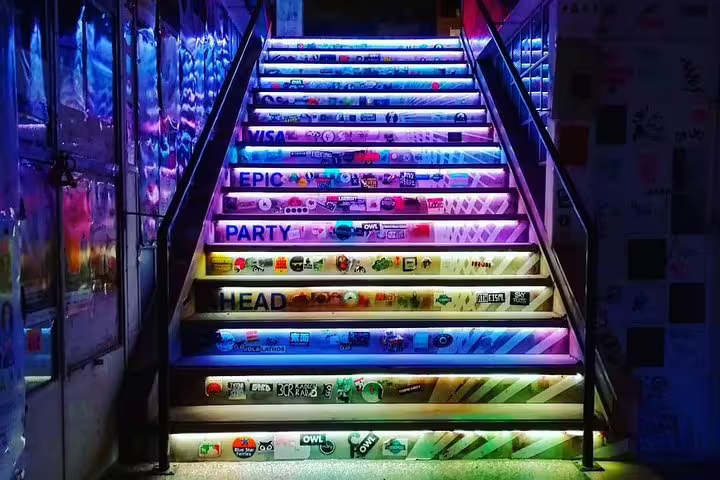 Neon-lit stairs at Athens nightlife stop on small group by night tour with drinks and street food tasting