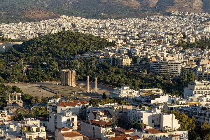 Athens cityscape with Temple of Olympian Zeus columns, en route landmark for private departure transfer to Piraeus