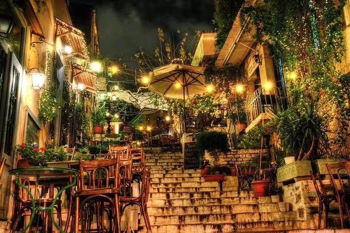 Plaka night scene with lantern-lit steps and cozy taverna tables, perfect for an Athens evening walking tour