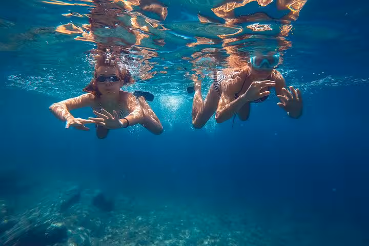 Snorkeling in crystal-clear Saronic Gulf waters on an Athens all-day cruise with island swim stop