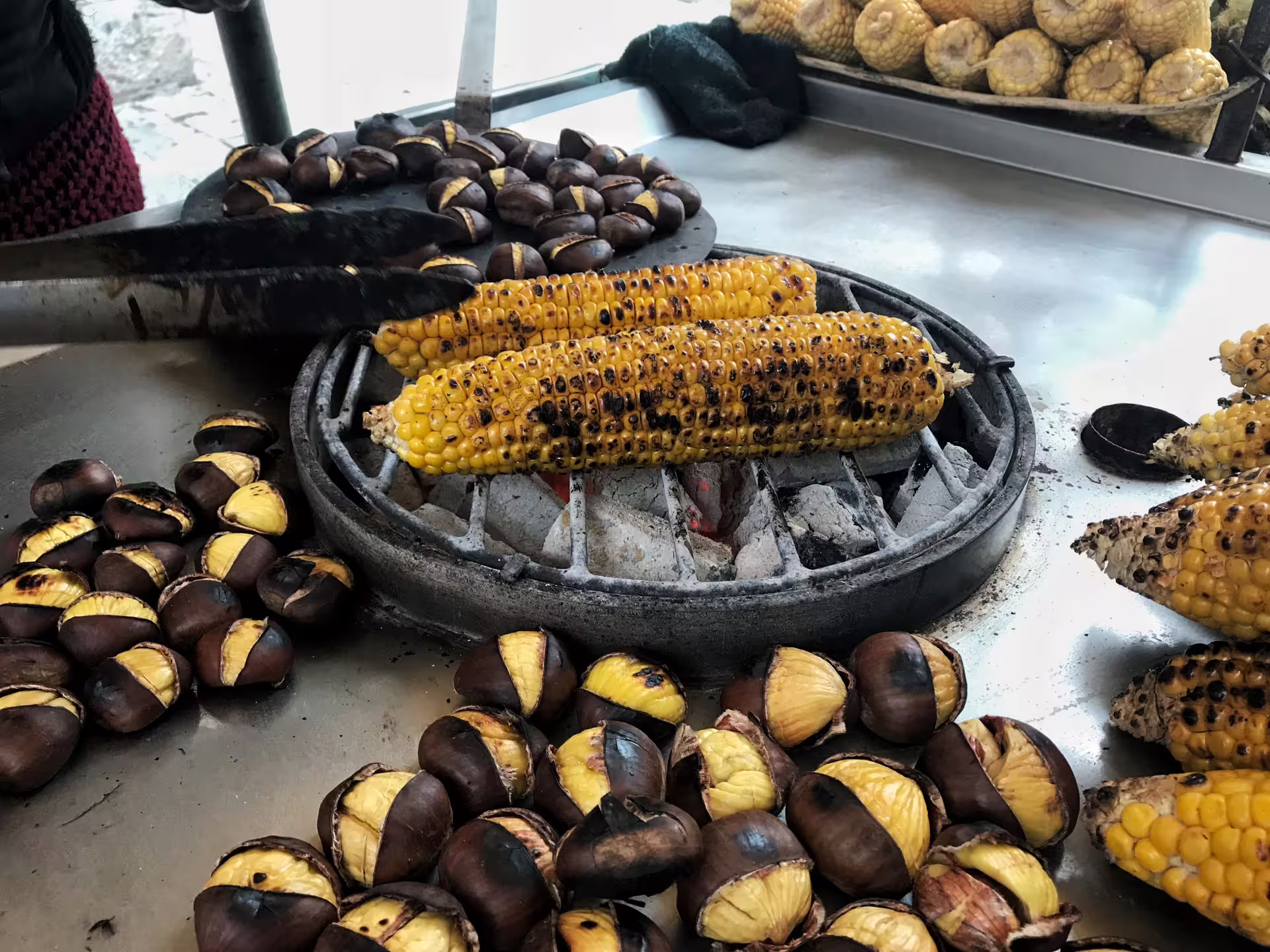 Street vendor grilling corn and roasting chestnuts, a classic Taste of Athens small-group afternoon food tour bite