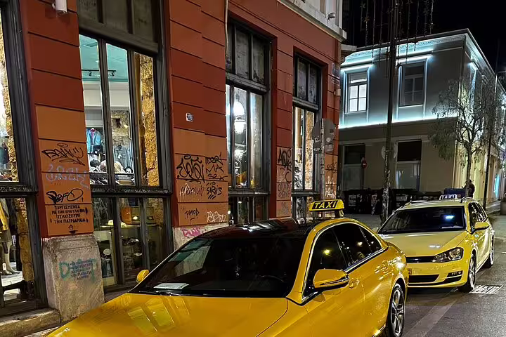 Yellow taxis at night in central Athens, ideal pickup for a 2-hour private express highlights tour
