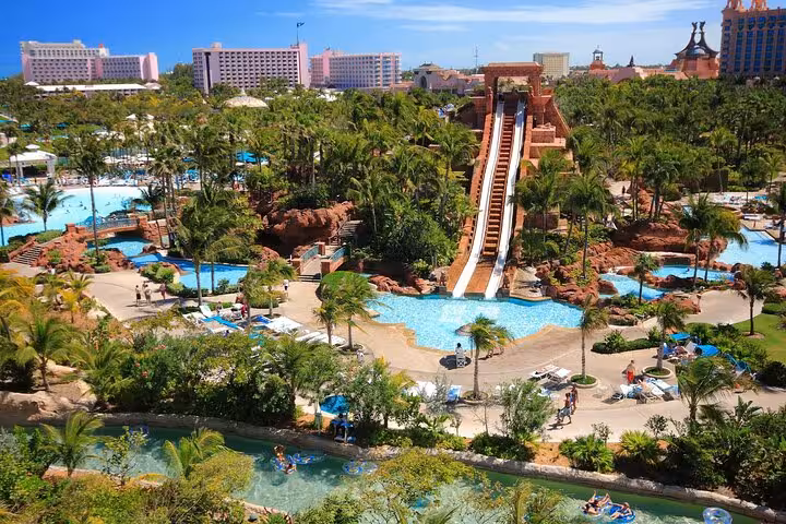 Aquaventure Atlantis Dubai waterpark tower slide into lagoon pools amid palm gardens, Atlantis Super Pass access