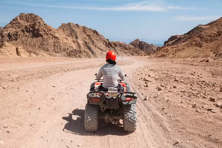 Single rider on quad bike crossing Hurghada desert mountains on ATV safari combo tour with camel ride in Egypt