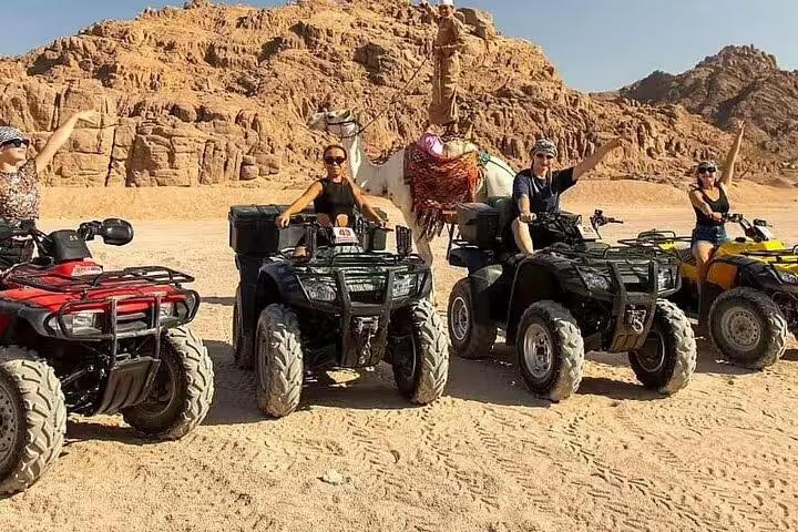 ATV quad biking near rocky Sinai mountains with camel stop on Sharm El Sheikh desert safari tour