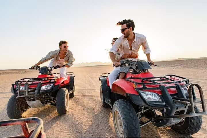 Tourists riding red ATV quad bikes in Sinai desert from Sharm el Sheikh, adventure before dinner and stargazing