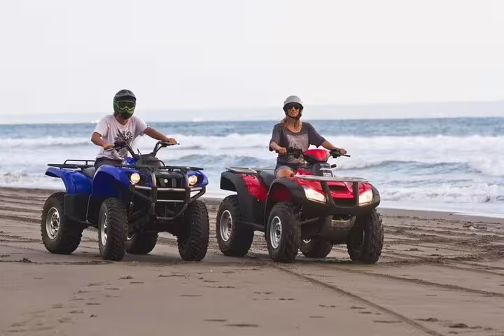 Couple riding ATVs on Marsa Alam beach by the Red Sea, quad bike safari adventure tour with ocean views