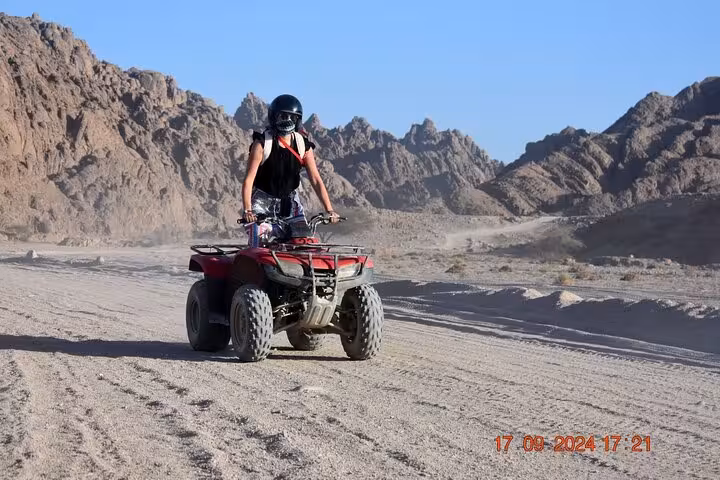 Solo rider on ATV quad bike in Sharm El-Sheikh Sinai mountains, off-road desert safari activity