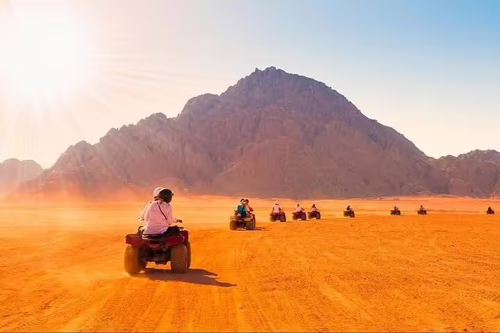 Sunset ATV quad bike safari adventure tour from Sharm El Sheikh riding across golden Sinai desert dunes