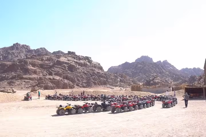 Large lineup of quad bikes ready for an ATV safari across Sharm El Sheikh desert with Sinai mountains backdrop