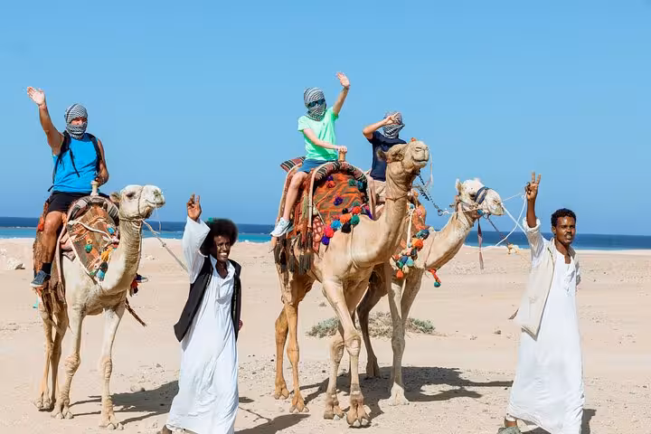 Tourists on camel ride in Sharm El Sheikh desert by the sea, part of Echo Mountain safari adventure