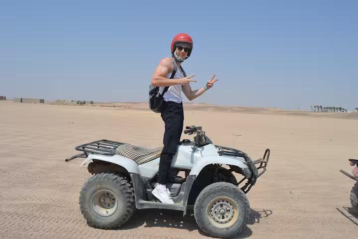 Rider posing on ATV quad in Sharm El Sheikh desert, Red Sea dunes sunrise or sunset adventure tour