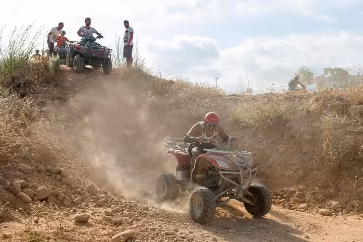 ATV rider speeds down rocky dusty trail during Antalya quad safari, off-road adventure in countryside