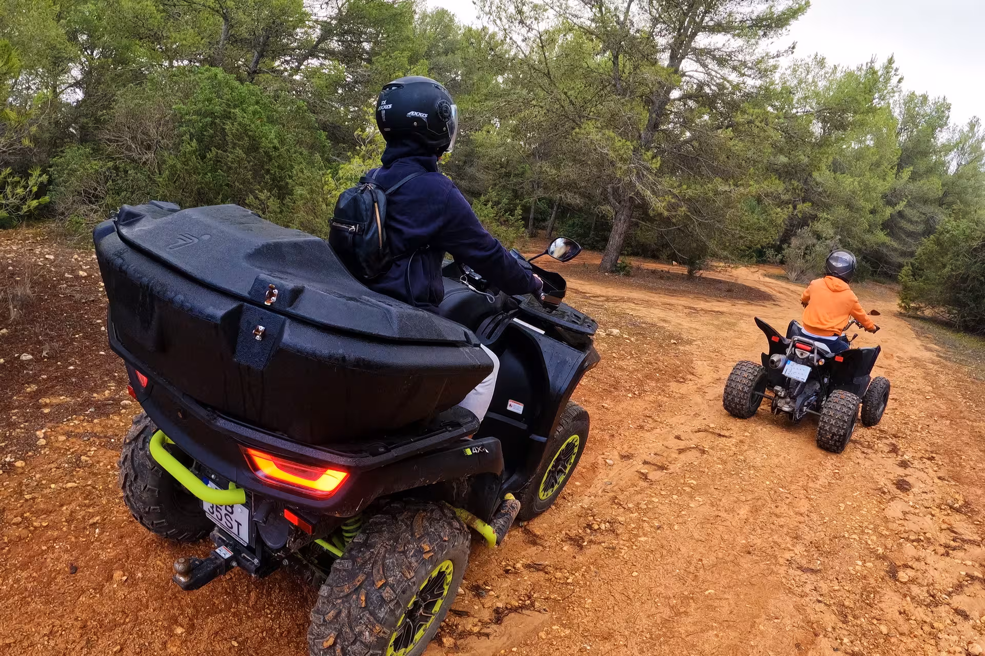 Adventurers on ATVs navigate a dirt trail surrounded by lush greenery in the seven Hanging Valleys, perfect for exploring.