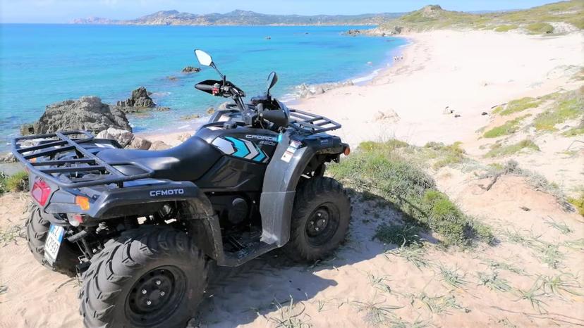 ATV parked on sandy cliff with stunning beach views, highlighting Santa Teresa di Gallura's thrilling 3-hour tour.